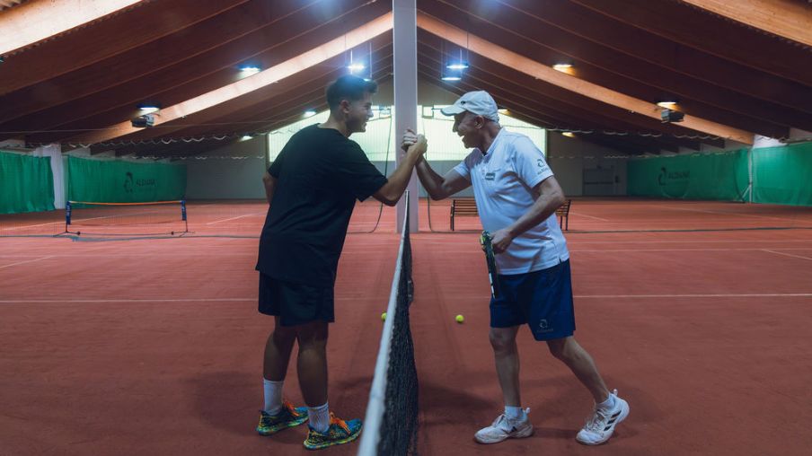 Zwei Männer in der Tennishalle geben sich die Hand 