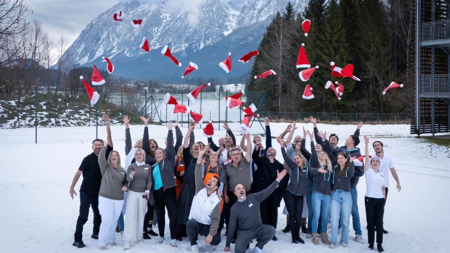 Gruppenbild im Winter, Leute werden Weihnachtsmützen in die Luft