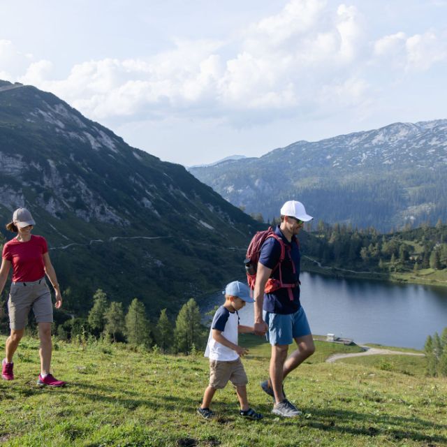 Familie bei einer Wanderung auf der Tauplitz mit See im Hintergrund