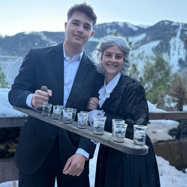 Zwei Leute lächeln in die Kamera mit Schnapsgläser