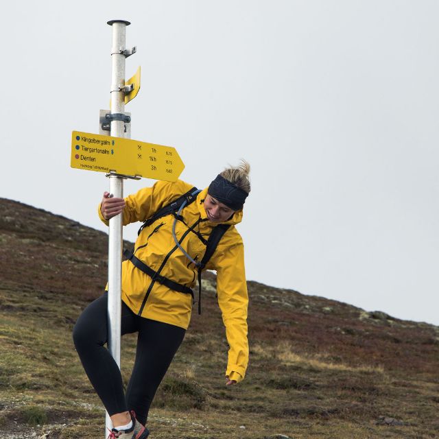 Frau beim Wandern im Herbst mit Richtungspfeil 