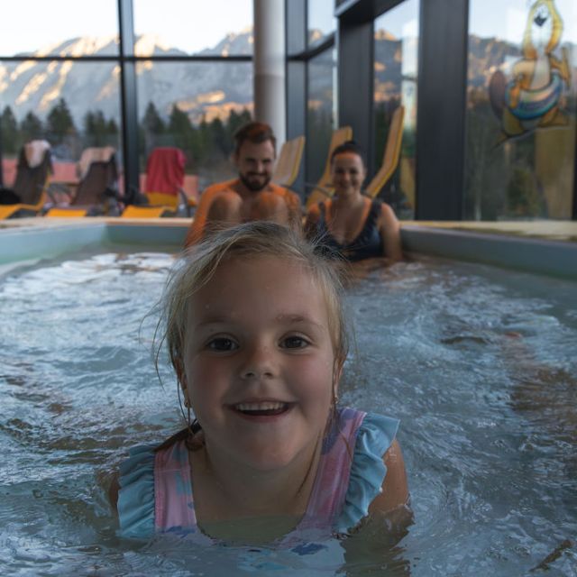 Kleines Mädchen lächelt in die Kamera im Wasser
