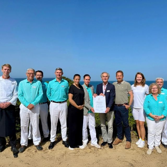 Teambild am Strand mit dem Travelife Award