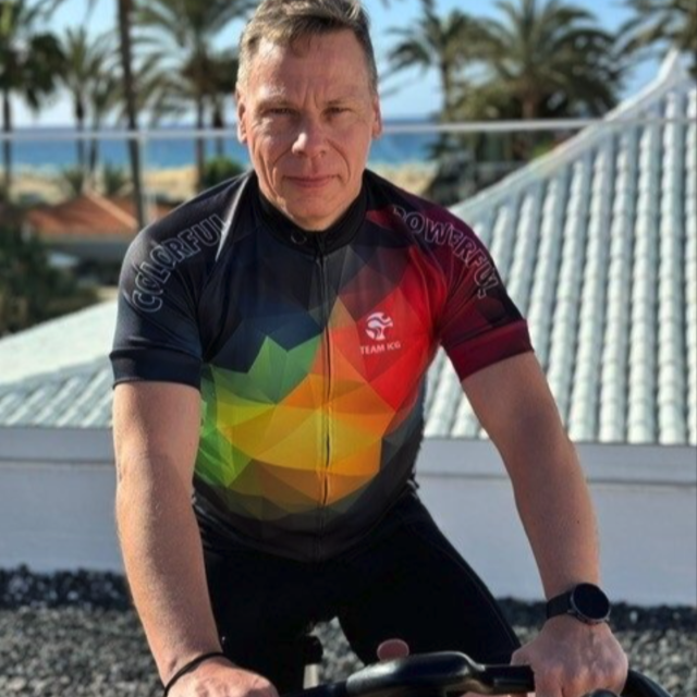 Mann sitz auf dem Rad und schaut in die Kamera