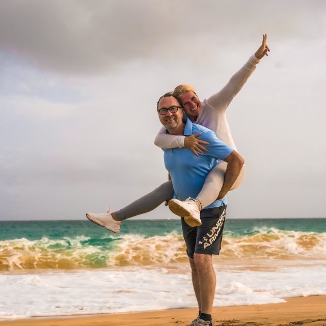 Zwei Menschen am Strand lächeln in die Kamera