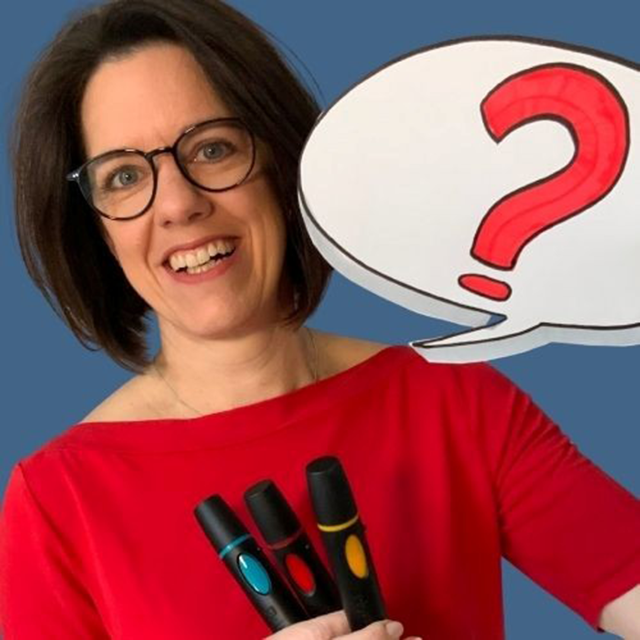 Frau lächelt in die Kamera und hält Stifte in der Hand