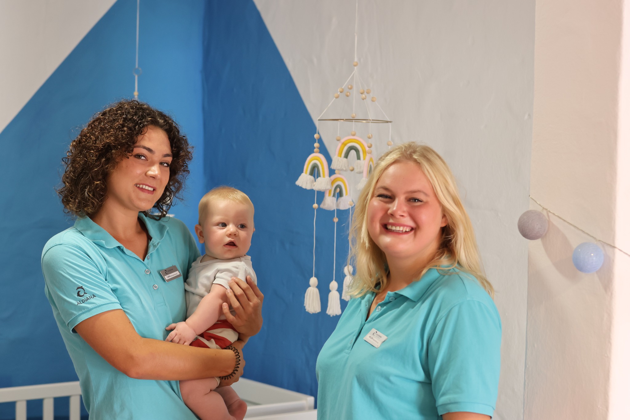 Zwei Personen mit Baby bei der Babybetreuung